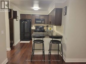 Toronto (Agincourt South-Malvern West) condo for rent - A kitchen with a black fridge, stove, and bar stools.