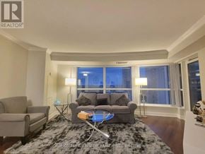 Toronto (Agincourt South-Malvern West) condo for rent - A living room with a grey couch and a black and white rug.