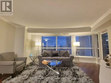 Toronto (Agincourt South-Malvern West) condo for rent - A living room with a grey couch and a black and white rug.