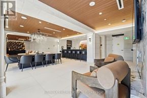 King (King City) condo for rent - A modern living room with a bar area and a television.