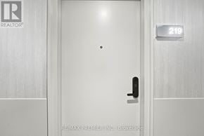King (King City) condo for rent - A white door with a black handle and a sign above it that says 219.