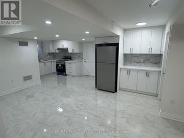 Brampton (Toronto Gore Rural Estate) apartment for rent - A spacious kitchen with white cabinets and marble flooring.