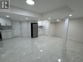 Brampton (Toronto Gore Rural Estate) apartment for rent - A spacious room with a kitchenette and a refrigerator.