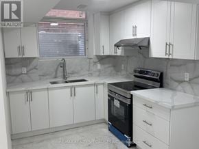 Brampton (Toronto Gore Rural Estate) apartment for rent - A kitchen with white cabinets and a black oven.