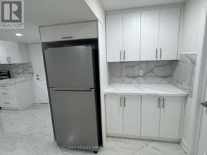 Brampton (Toronto Gore Rural Estate) apartment for rent - A kitchen with a refrigerator, cabinets, and a marble countertop.
