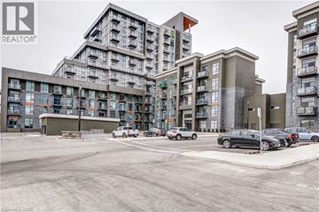 Waterdown condo for rent - A modern apartment complex with multiple buildings and cars parked in front.