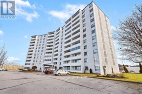 St. Catharines (Glendale/Glenridge) condo for rent - A large white building with a parking lot in front of it.