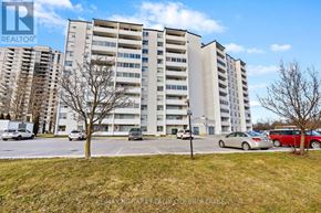 St. Catharines (Glendale/Glenridge) condo for rent - A large apartment building with a parking lot in front.