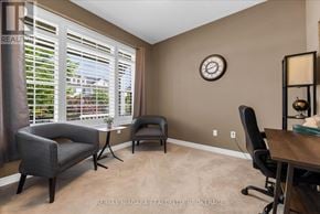 Niagara-On-The-Lake (Glendale) apartment for rent - A living room with a grey chair, a black chair, and a wooden table.
