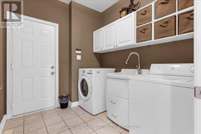 Niagara-On-The-Lake (Glendale) apartment for rent - A laundry room with a washer and dryer, a sink, and a cabinet with storage bins.
