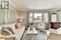 Toronto (Wexford-Maryvale) apartment for rent - A living room with a white couch, a glass coffee table, and a large painting on the wall.