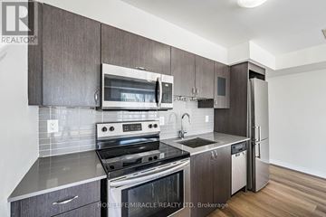 Toronto (Downsview-Roding-Cfb) townhouse for rent - A modern kitchen with dark wood cabinets and stainless steel appliances.