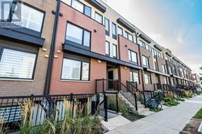 Toronto (Downsview-Roding-Cfb) townhouse for rent - A row of townhouses with a bicycle leaning against the railing.