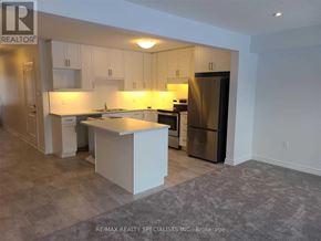 Grey Highlands townhouse for rent - A kitchen with white cabinets and a stainless steel refrigerator.