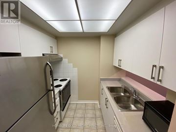 Toronto (Newtonbrook East) condo for rent - A kitchen with white cabinets and a stainless steel refrigerator.