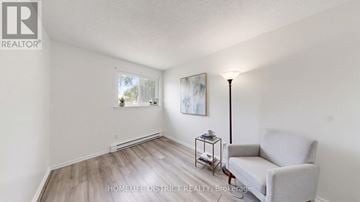 Oshawa (Lakeview) apartment for rent - A living room with a grey sofa and a small table with a lamp on it.