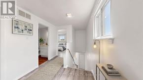 Oshawa (Lakeview) apartment for rent - A well-lit hallway with a carpeted floor and a window on the right side.