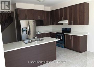 Oshawa (Windfields) apartment for rent - A kitchen with brown cabinets and a white counter top.