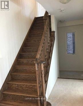 Oshawa (Windfields) apartment for rent - A wooden staircase in a house with a window in the background.