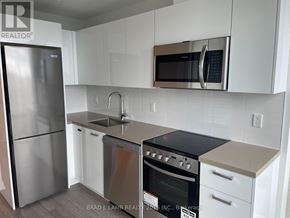 Toronto (Moss Park) condo for rent - A kitchen with a stainless steel refrigerator, microwave, and oven.