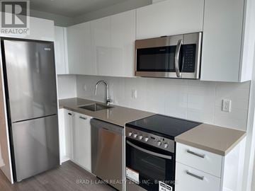 Toronto (Moss Park) condo for rent - A kitchen with a stainless steel refrigerator, microwave, and oven.