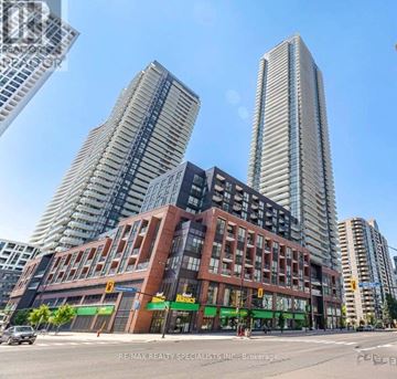 Mississauga (City Centre) condo for rent - A city street with a building that has a sign that says "RE/MAX REALTY SPECIALISTS INC., BROKERAGE".