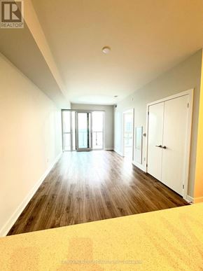 Mississauga (City Centre) condo for rent - A spacious room with wooden floors and white walls.