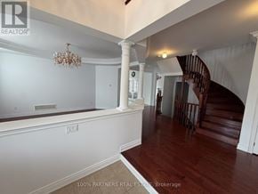Vaughan (Patterson) apartment for rent - A chandelier hangs over a white wall in a room with wood floors and a spiral staircase.