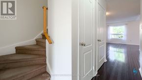 Mississauga (Churchill Meadows) townhouse for rent - A hallway with a white door and a staircase with a wooden handrail.