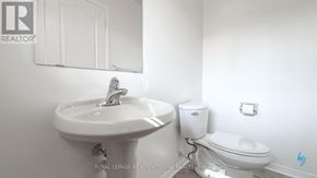 Mississauga (Churchill Meadows) townhouse for rent - A white sink with a chrome faucet is on the left of a white toilet in a white bathroom.