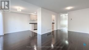 Mississauga (Churchill Meadows) townhouse for rent - A spacious room with wooden floors and white walls.