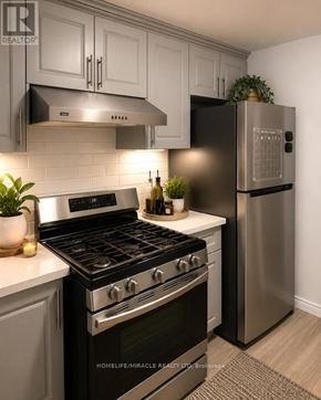 London North (North C) apartment for rent - A modern kitchen with a stainless steel refrigerator and a black stove top oven.