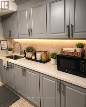 London North (North C) apartment for rent - A kitchen with grey cabinets and a black microwave.