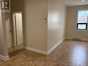Fort Erie (Ridgeway) apartment for rent - A room with beige walls and tiled flooring with a door and window.