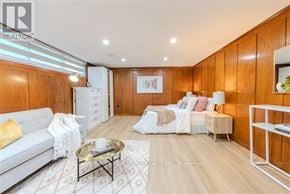 Toronto (Bathurst Manor) apartment for rent - A modern living room with a white sofa, a coffee table, and a bed with white bedding.