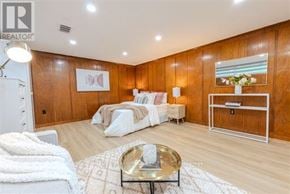 Toronto (Bathurst Manor) apartment for rent - A bedroom with a bed, nightstand, and a table with a vase of flowers on it.
