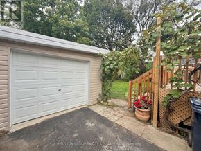 Toronto (Downsview-Roding-Cfb) apartment for rent - A white garage door is closed and there is a wooden fence in front of it.