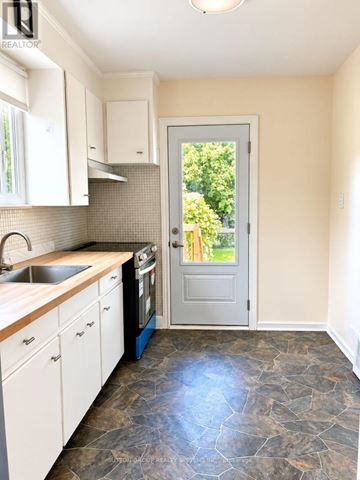 Toronto (Downsview-Roding-Cfb) apartment for rent - A kitchen with a sink, stove, and cabinets.