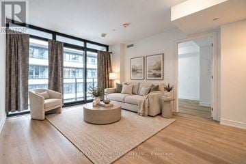 Hamilton (Beasley) condo for rent - A living room with a large window, a sofa, a chair, and a coffee table.
