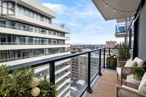 Hamilton (Beasley) condo for rent - A balcony with a table and chairs overlooks a cityscape.