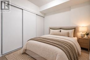 Hamilton (Beasley) condo for rent - A bedroom with a bed, nightstand, and sliding door.