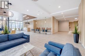 Kitchener condo for rent - A spacious living room with a blue sofa and a dining area in the background.