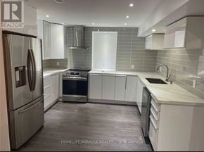 Clarington (Bowmanville) apartment for rent - A modern kitchen with a refrigerator, oven, and sink.