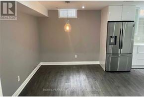 Clarington (Bowmanville) apartment for rent - A spacious room with a refrigerator on the right side.