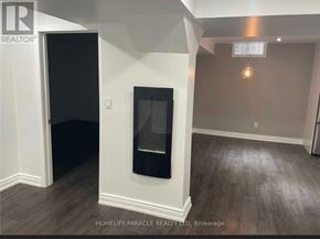 Clarington (Bowmanville) apartment for rent - A room with a fireplace and a light on.