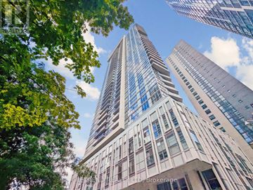 Toronto (Church-Yonge Corridor) condo for rent - A tall building with many windows is surrounded by trees.