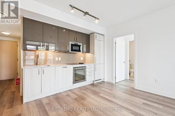 Toronto (Church-Yonge Corridor) condo for rent - A modern kitchen with white cabinets and a wooden floor.