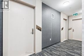 Toronto (Church-Yonge Corridor) condo for rent - A hallway with doors and a green exit sign.