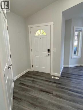 Calgary apartment for rent - A white door with a window above it in a room with wooden flooring.