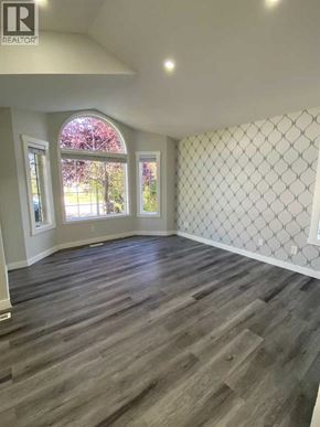 Calgary apartment for rent - A room with wooden flooring and a diamond patterned wallpaper.